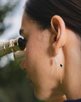 Aros colgantes Sophia Schneider Joyas de oro 18K con tres perlas naturales redondas en una modelo al aire libre
