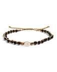 Pulsera ClaraJoyas de hilo dorado ajustable con cuentas de ónix negro y una perla central blanca