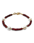 Pulsera ClaraJoyas de hilo dorado con perlas blancas naturales y piedras granates facetadas en un diseño elegante