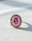 Anillo de platino con rubí oval central, halo doble de brillantes y rubíes, de Sophia Schneider Joyas.