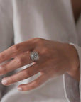 Anillo solitario Sophia Schneider Joyas de platino con topacio rectangular biselado y halo de brillantes.