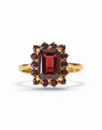 Sophia Schneider Joyas 14K gold ring featuring a rectangular garnet center stone surrounded by smaller garnets in a floral halo design.