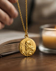 Medalla redonda de San Benito en plata 925 enchapada en oro de Sophia Schneider Joyas, detalle religioso en relieve.
