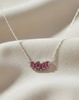 Sophia Schneider Joyas 14K gold necklace with a curved row of five baguette-cut rhodolite stones.