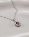 Sophia Schneider Joyas 14K white gold oval ruby and diamond halo pendant necklace.