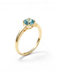 Sophia Schneider Joyas 18K gold ring with a round, blue topaz gemstone. Classic solitaire design.
