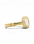 Sophia Schneider Joyas 18K gold ring with 1 ct oval lab-grown diamond, bezel set with pavé diamonds.