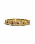 Sophia Schneider Joyas 18K yellow gold band ring with alternating round rubies and ornate filigree details.