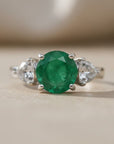 Sophia Schneider Joyas sterling silver ring with a central oval green emerald and two pear-cut white topaz stones.