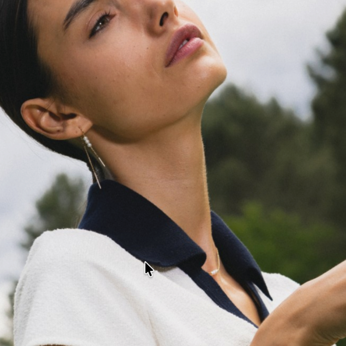Modelo luciendo aros colgantes Sophia Schneider Joyas de oro 18K con tres perlas naturales redondas en exterior.