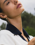 Modelo luciendo aros colgantes Sophia Schneider Joyas de oro 18K con tres perlas naturales redondas en exterior.