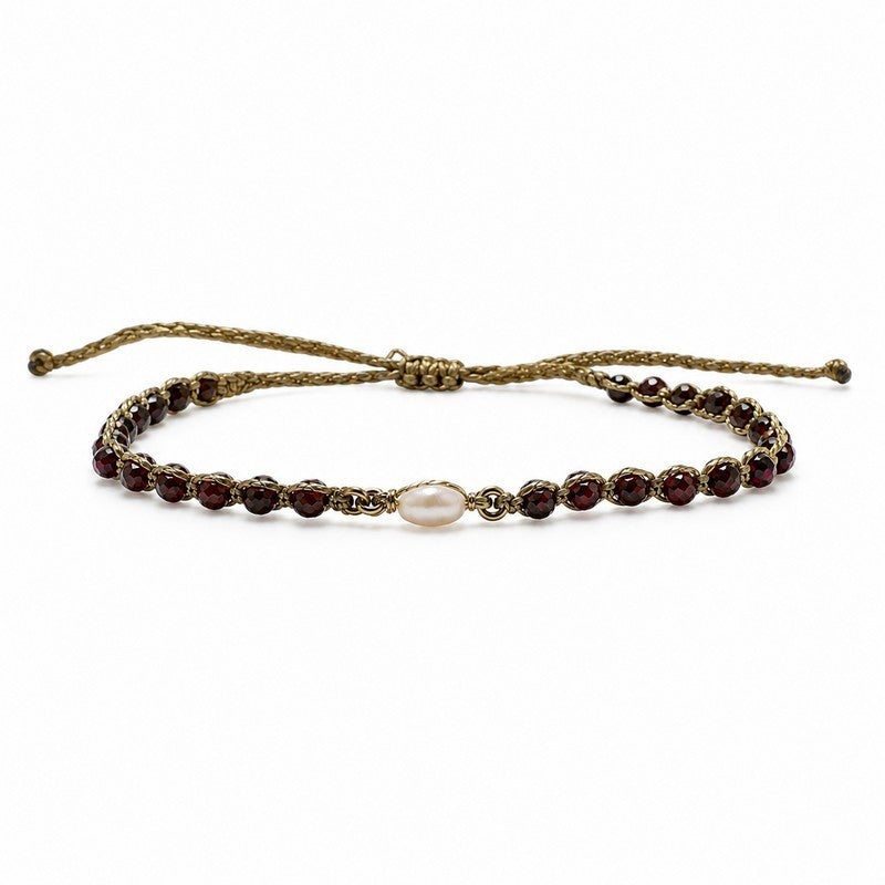 Pulsera ajustable ClaraJoyas de hilo dorado con perla central y cuentas de granate rojo sobre fondo blanco