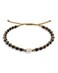 Pulsera ajustable ClaraJoyas de hilo dorado con cuentas de Onix negro y una perla central blanca