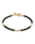 Pulsera ClaraJoyas de cuentas de ónix negro facetado con tres perlas blancas y detalles dorados, ajustable de 16 cm.
