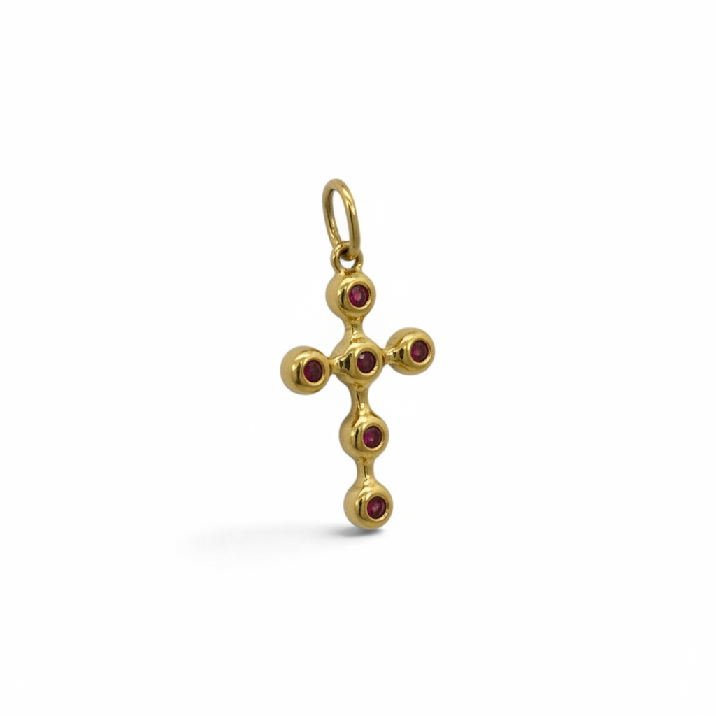 Cruz Sophia Schneider Joyas de oro 18K con seis rubíes engastados en bisel, diseño artesanal de 36x18 mm.