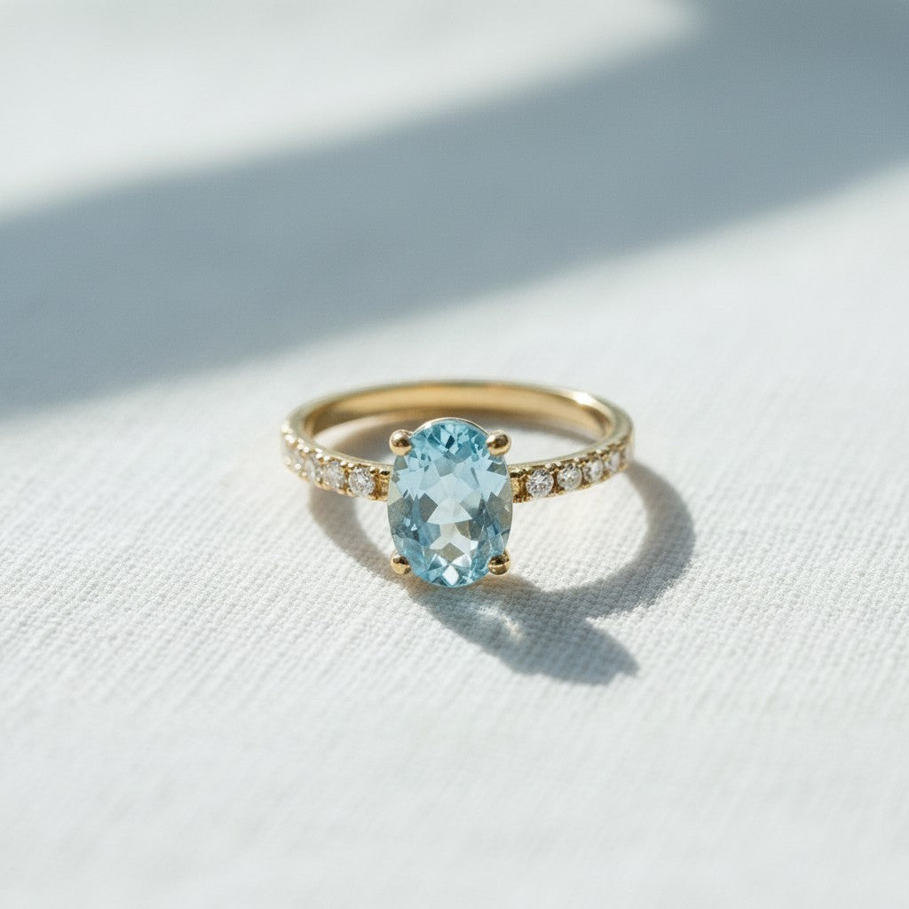 Anillo de oro amarillo 18k de Sophia Schneider Joyas con aguamarina oval y diamantes en la argolla.