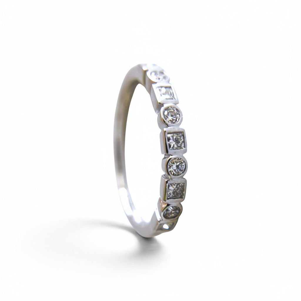 Anillo cintillo Sophia Schneider Joyas de oro blanco 14K con diamantes corte brillante y princesa en engaste bisel