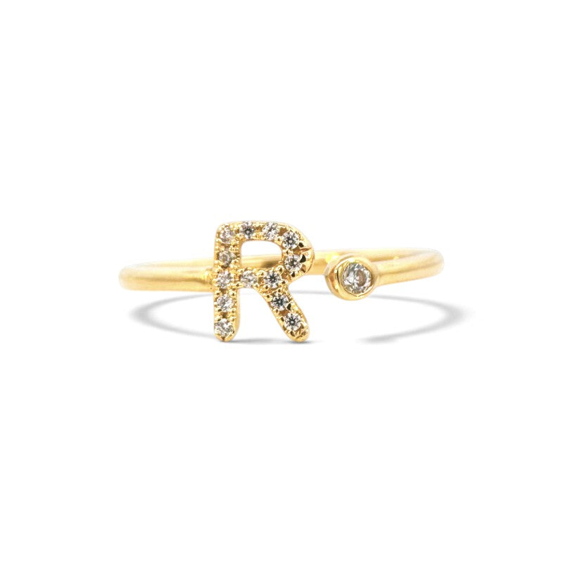 Anillo abierto Sophia Schneider Joyas de oro 18K con letra R decorada con brillantes y un diamante en bisel.