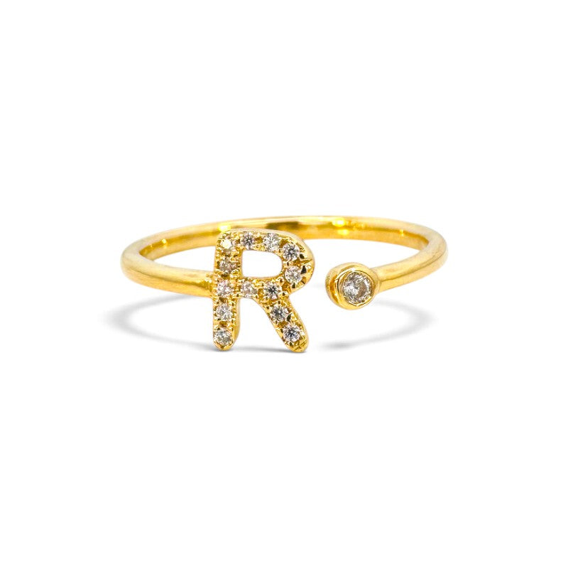 Anillo abierto Sophia Schneider Joyas de oro 18K con letra R decorada con brillantes y un diamante en bisel.