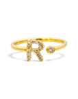 Anillo abierto Sophia Schneider Joyas de oro 18K con letra R decorada con brillantes y un diamante en bisel.