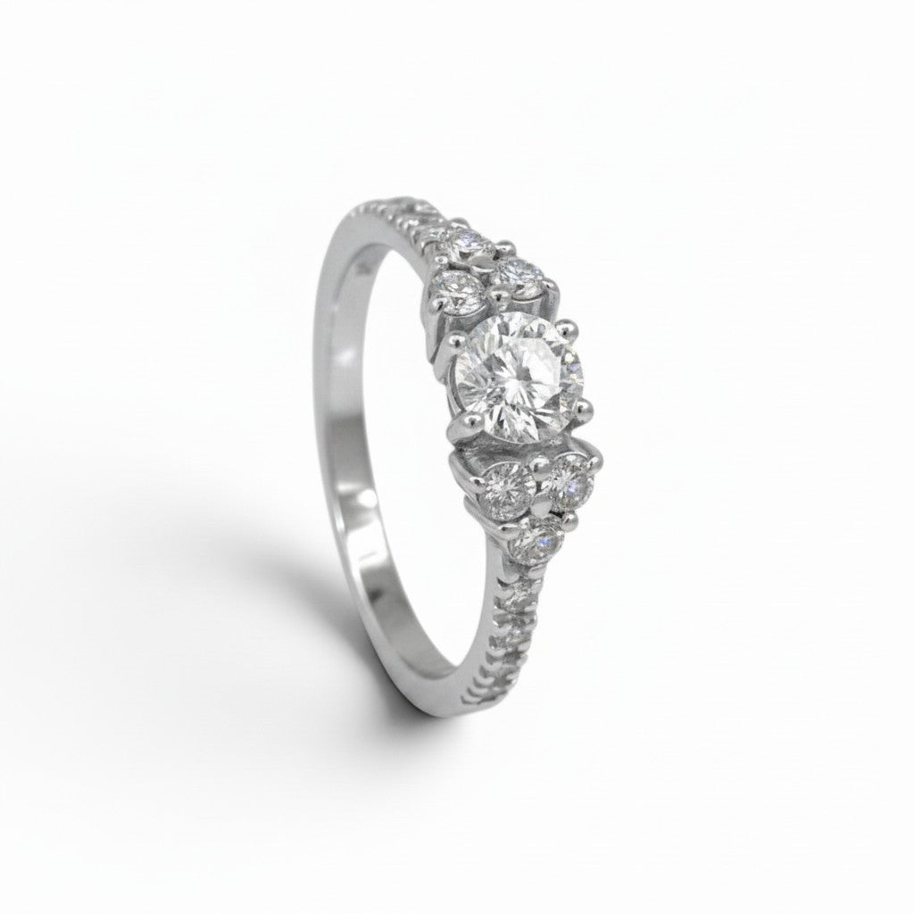 Anillo solitario Sophia Schneider Joyas de platino con diamante central y seis brillantes laterales en engaste fino.