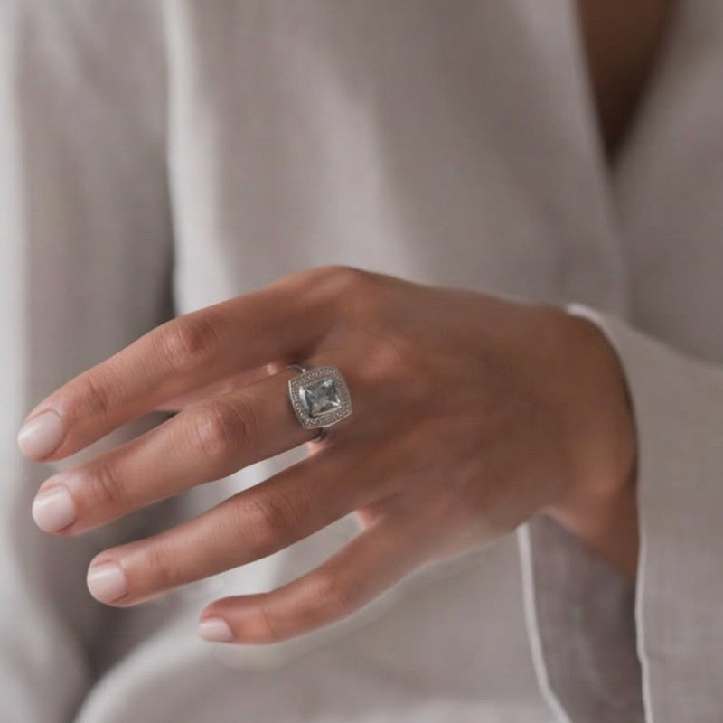 Anillo solitario Sophia Schneider Joyas de platino con topacio rectangular biselado y halo de brillantes.