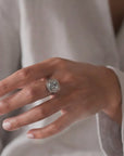 Anillo solitario Sophia Schneider Joyas de platino con topacio rectangular biselado y halo de brillantes.