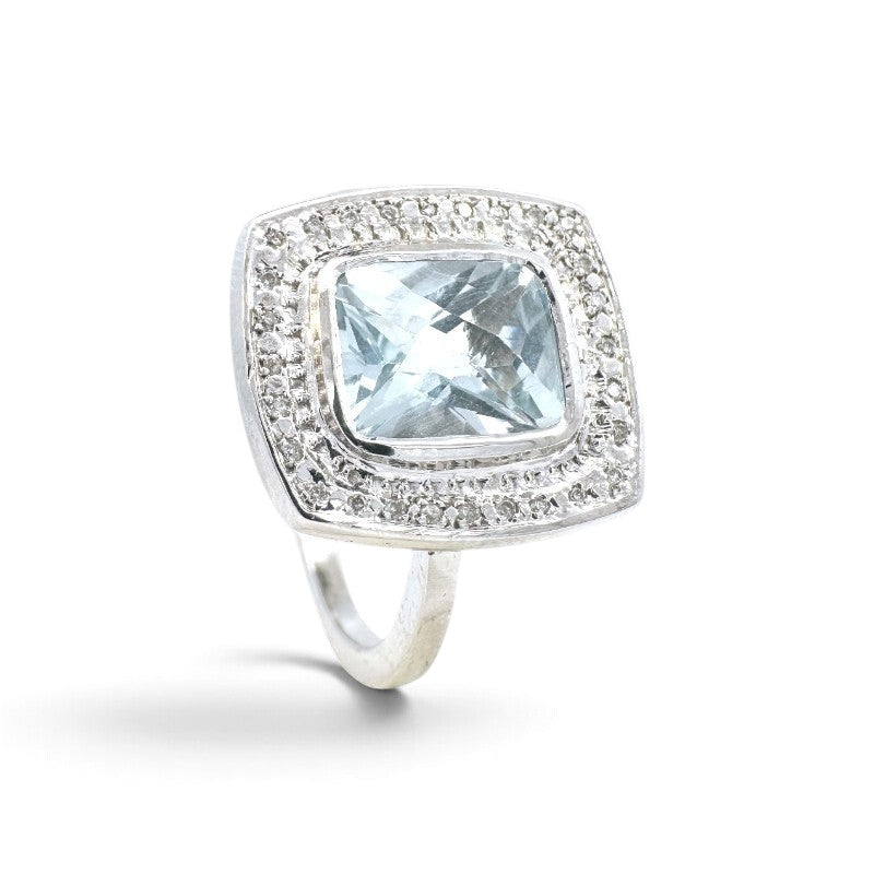 Anillo Sophia Schneider Joyas de platino con topacio azul rectangular en bisel y halo de brillantes