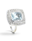 Anillo Sophia Schneider Joyas de platino con topacio azul rectangular en bisel y halo de brillantes