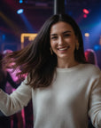 Mujer sonriente luciendo aros de flores con gota en plata enchapada en oro de Sophia Schneider Joyas en una fiesta