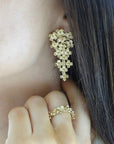 Aros colgantes de flores en plata enchapada en oro de Sophia Schneider Joyas con diseño de gota en movimiento