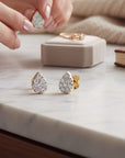 Aros stud Sophia Schneider Joyas en forma de gota de oro blanco 10K con diamantes pavé de 0,20 ct sobre mesa de mármol