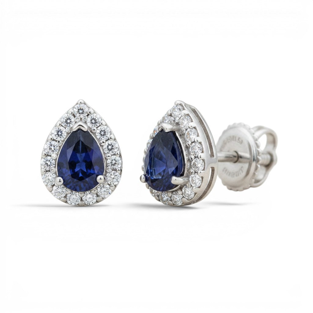 Aros stud Sophia Schneider Joyas de oro blanco 14K con zafiro azul en corte pera y halo de brillantes