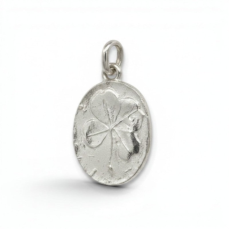 Colgante amuleto trébol de la suerte en plata de Sophia Schneider Joyas. Diseño ovalado con trébol grabado.