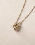 Collar Sophia Schneider Joyas con cruz tridimensional de oro 18K y diamantes brillantes sobre fondo neutro