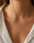 Collar Sophia Schneider Joyas de plata 925 bañada en oro con cruz pequeña y tres perlas naturales en la cadena.