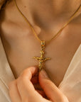 Colgante de cruz con Cristo en oro amarillo 10K de Sophia Schneider Joyas sobre el cuello de una mujer