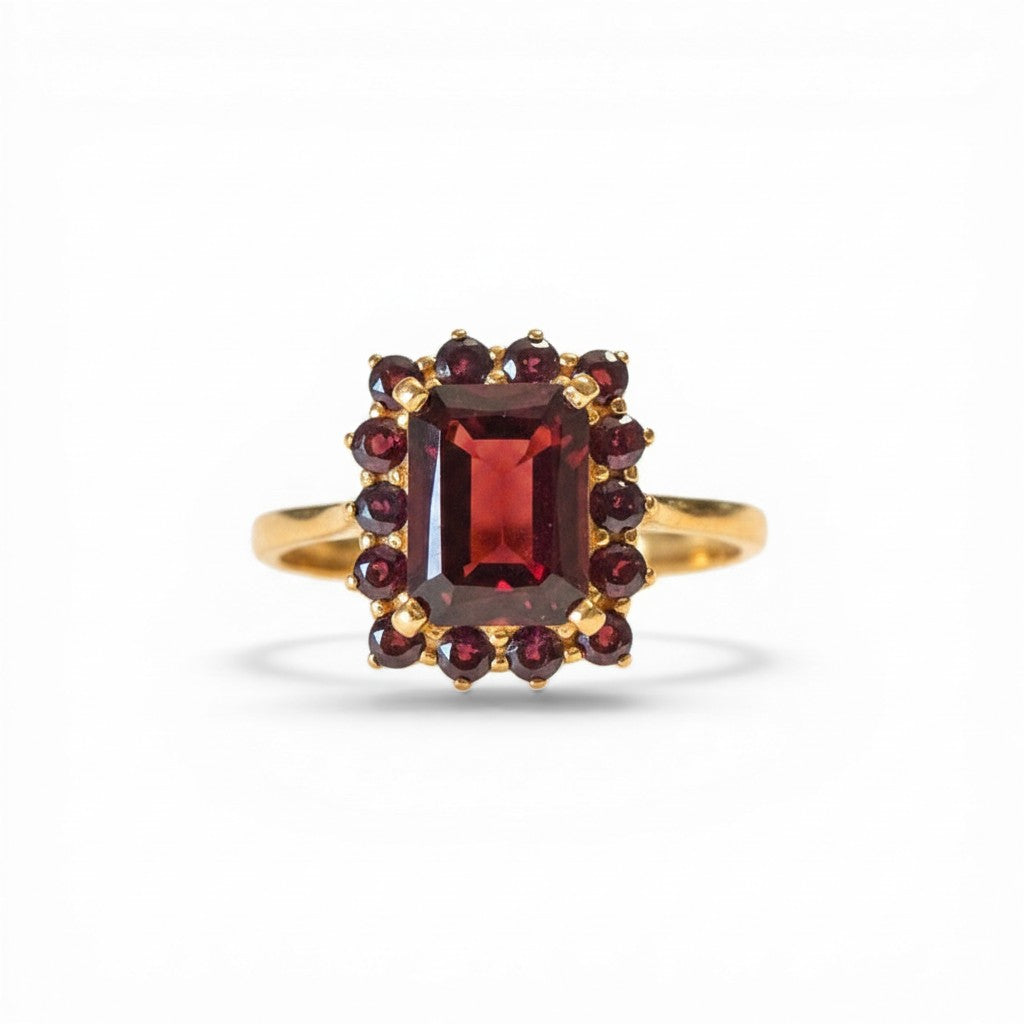 Sophia Schneider Joyas 14K gold ring featuring a rectangular garnet center stone surrounded by smaller garnets in a floral halo design.