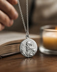 Medalla redonda de San Benito en plata 925 pulida de Sophia Schneider Joyas, detalle religioso en primer plano.