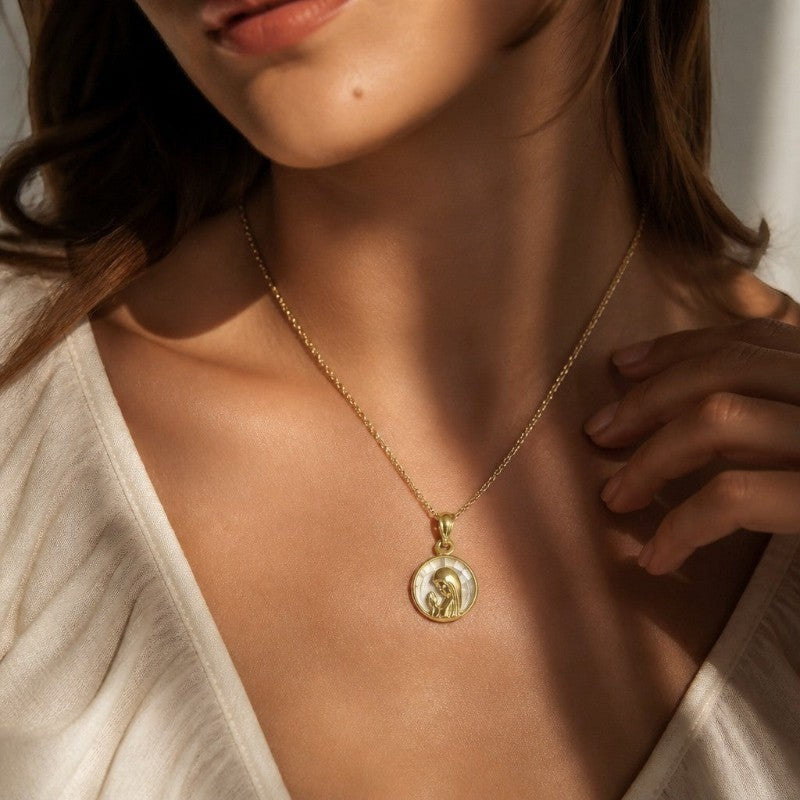 Medalla redonda de la Virgen orando en oro de 18K con cristal, de la marca Sophia Schneider Joyas, puesta en el cuello.