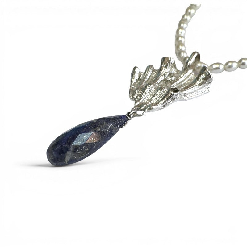 Sophia Schneider Joyas Maris necklace with pearls, silver, and lapis lazuli pendant. Textured silver pendant with a faceted teardrop lapis lazuli.