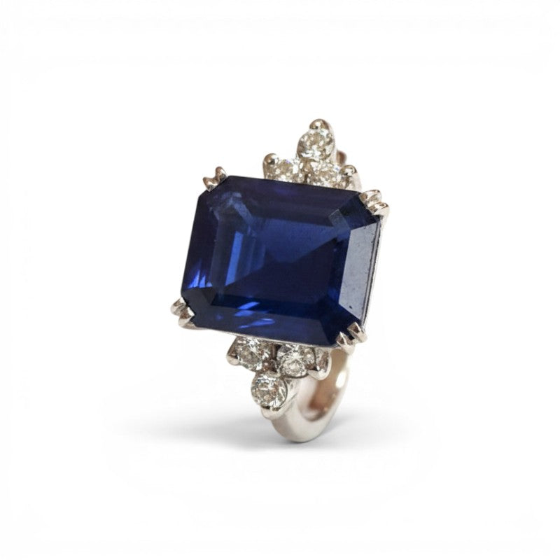 Sophia Schneider Joyas platinum ring with a large emerald-cut sapphire and surrounding diamonds.