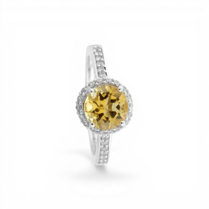 Sophia Schneider Joyas silver ring with a round yellow citrine/topaz center stone surrounded by small white stones.