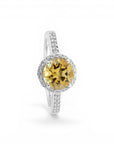 Sophia Schneider Joyas silver ring with a round yellow citrine/topaz center stone surrounded by small white stones.