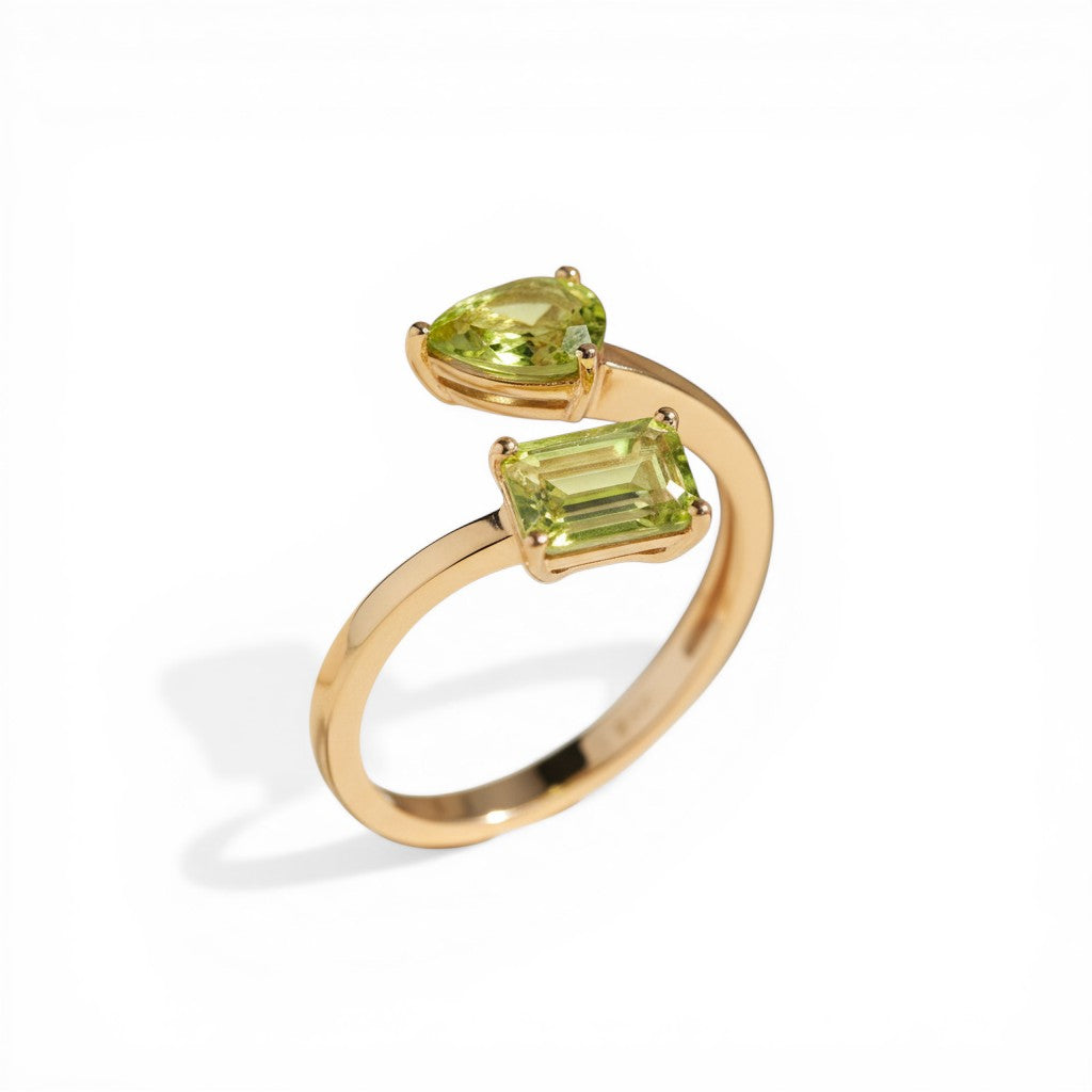 Sophia Schneider Joyas 14K gold ring with two peridot stones, one pear-cut and one emerald-cut.
