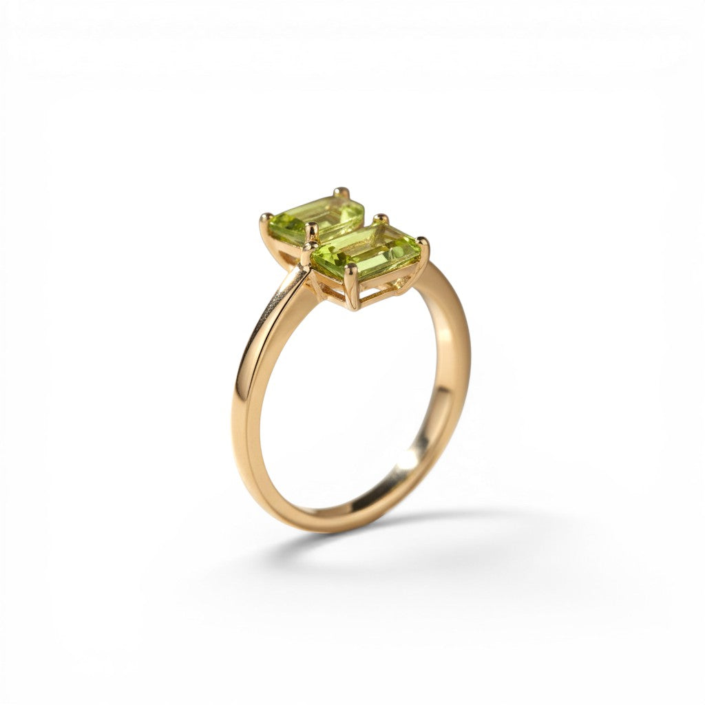 Sophia Schneider Joyas 14K gold ring with two emerald-cut peridot stones.