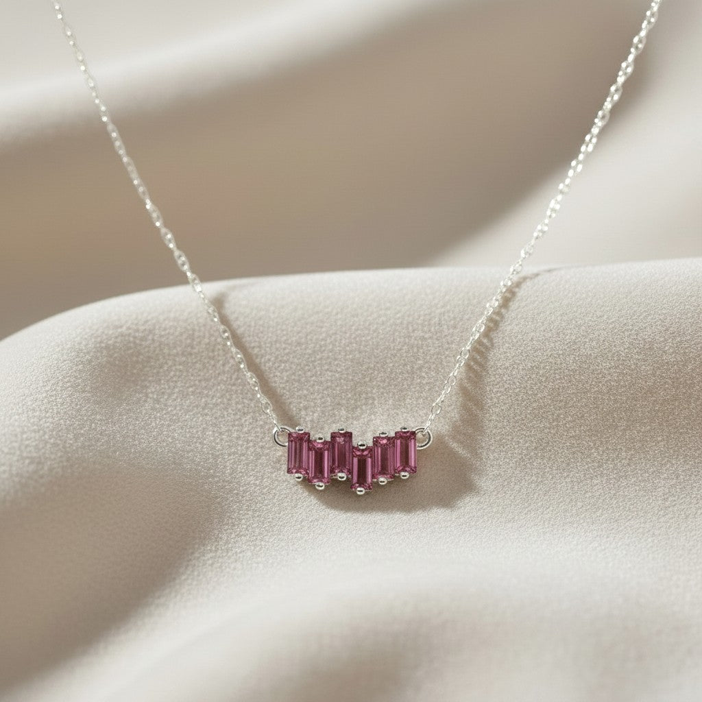 Sophia Schneider Joyas 14K gold necklace with a curved row of five baguette-cut rhodolite stones.