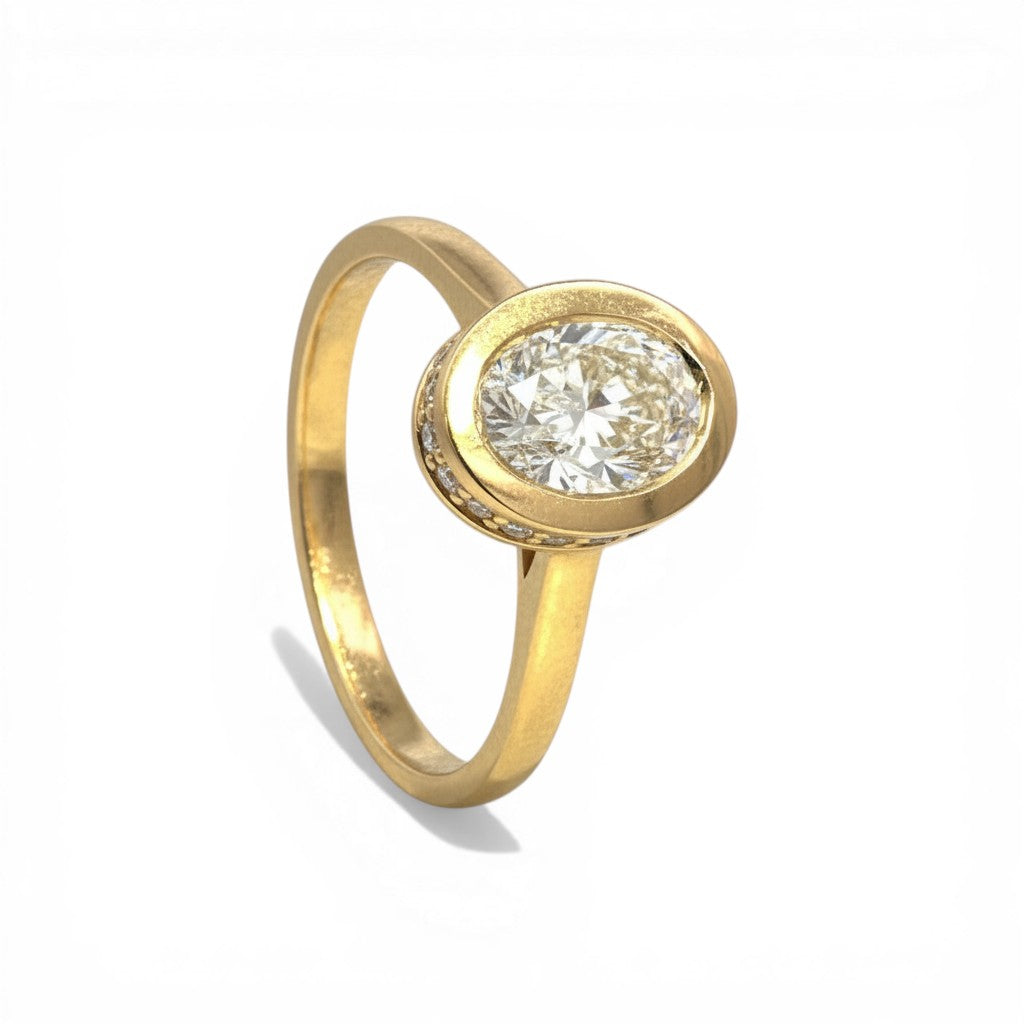 Sophia Schneider Joyas 18K yellow gold ring with 1 ct oval lab-grown diamond, bezel set with small accent diamonds.