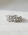 Anillo cintillo Sophia Schneider Joyas de platino con 7 diamantes centrales y 56 diamantes en halo, corte brillante.