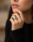 Anillo Sophia Schneider Joyas de platino con esmeralda central corte gota y halo de brillantes en la argolla.